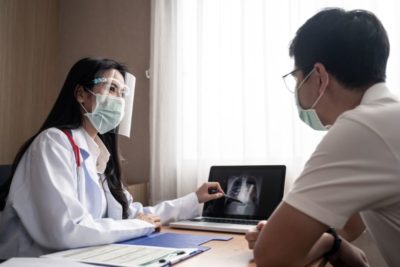 Female Doctor Interpreting Chest X-Ray on Laptop to Patient